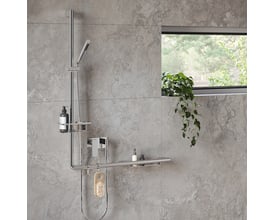 Smedbo Living kurv i poleret krom monteret på en brusestang med sæbe og en børste, som viser opbevaringsløsning i et moderne badeværelse.