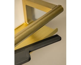 Tæt på en børstet messingfarvet Cosmic Architect S+ brusehylde med integreret bruseskraber. Hyldens kant ses tydeligt.