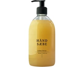 Flaske med flydende håndsåbe Golden Nectar 500 ml. Den gyldne sæbe har en sort pumpe og etikette med produktnavn og volumen.