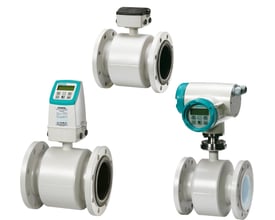 Tre forskellige Siemens SITRANS FM MAG 3100 magnetflowmålere med PN16 kulstofstål flanger og hvide PTFE linere, monteret på hvid baggrund.