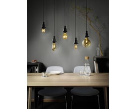Fem Osram Ledvance 1906 globe LED-pærer med røgfarvet glas og spiral filament, hængende over et spisebord i et moderne rum.