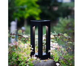 Eglo sort plast solcellelampe med spyd, 25,5 cm høj, placeret i blomsterbed med grønne planter.