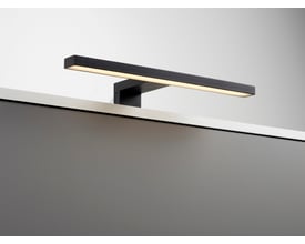 Loevschall Lagan NextGen spejllampe, 50 cm, i sort metal, der sidder på kanten af et spejl eller skab med varmt hvidt LED-lys.