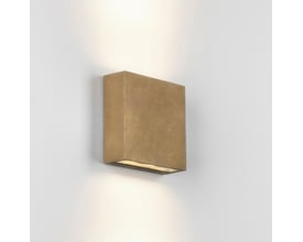 Astro Lighting Elis Coastal Twin LED væglampe i massiv messing, monteret på en hvid væg med lys der skaber op- og nedadgående lyskegler.