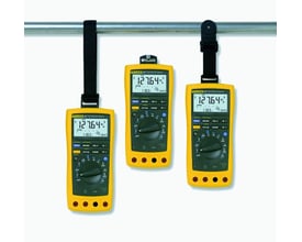 Tre gule Fluke multimetre hængt op på en stang ved hjælp af Toolpak meterophængssætets stropper og magnet.