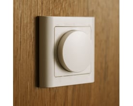 Niko DALI-2 lysdæmper i hvidt, dansk design, monteret på en trævæg med en rund drejeknap for lysjustering.