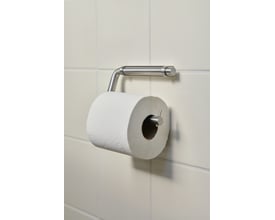 Nærbillede af Knud Holscher toiletrulleholder fra d line i børstet stål, der holder en toiletpapirrulle på en lys flisevæg.