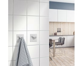 Smedbo Beslagsboden selvklæbende enkelkrog i børstet stål, 45 mm, monteret på hvidt badeværelsesflise, med et ternet viskestykke hængende.