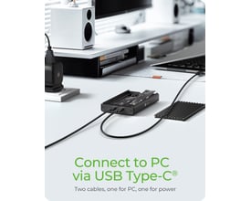 Sort ICY BOX-kabinet til to M.2 PCIe NVMe-SSD'er er tilsluttet med kabler på et skrivebord.