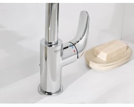 Grohe Swift etgrebs armatur i krom med blank overflade og indbygget løft-op bundventil ved siden af sæbe.