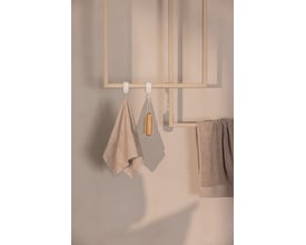 Metallbude Tensi håndklædeholder i beige med to håndklæder og en vaskebørste hængende på hvid krog.