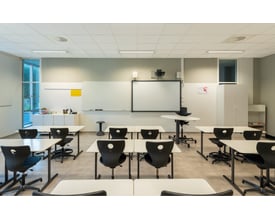 SG Armaturen Ecoline Connect 1600 lysarmatur med hvidt lys (4000K) installeret i et lyst undervisningslokale med borde og stole.