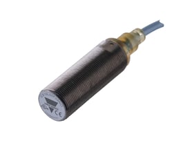 Carlo Gavazzi induktivaftaster M18, skærmet model med 5 mm detekteringsafstand og fast kabel, vist skråt.