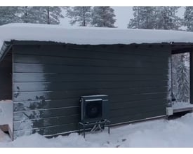 Panasonic CU-2Z50ABEC udedel monteret udenfor et hus om vinteren, dækket af sne og frost.