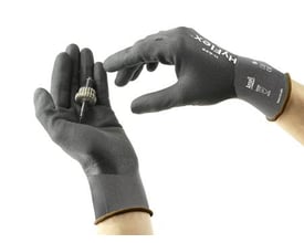 Ansell HyFlex 11-849 handske i str. 8 viser hvordan den forbedrede grebsevne kan håndtere et lille metalemne.