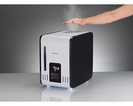 En hånd fører over dampen fra Boneco S450 luftfugteren, der viser dens varmdampfunktion.