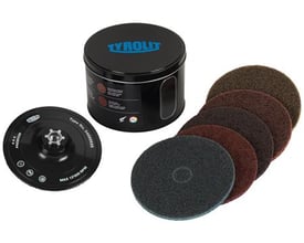 Tyrolit SCM Kit 115 med fem forskellige slibeskiver og bagflange i sort metaldåse på hvid baggrund.