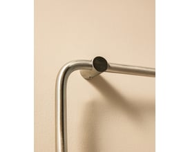 Cosmic Logic håndklædeholder, 20 cm, i poleret rustfrit stål, monteret på en lys væg.