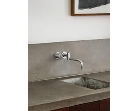Vola håndvaskarmatur 131 i rustfrit stål med etgrebsbetjening og 250mm svingtud monteret på væg over betonkant.
