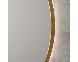 Nærbillede af Sanibell INK SP17 spejl med mat guld aluramme og indirekte LED-belysning mod en råhvid baggrund.