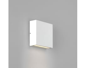 Astro Lighting Elis Single væglampe i hvid på grå væg, viser varmt lys nedad.