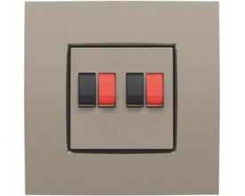 Niko afdækning til dobbelt højtalerudtag i elegant bronze finish med to sorte og to røde terminaler på en neutral baggrund.