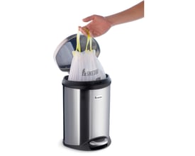 Hånd der trækker en Smedbo Xtra pedalspands pose op af en rustfri stål pedalspand med hvid baggrund.