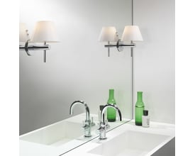 Astro Roma væglampe i krom med opal glasskærm, monteret over et hvidt badeværelsesmøbel med vaske og grønne flasker.