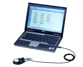 En Dell bærbar computer viser et regneark med data, forbundet via USB-kabel til et digitalt mikrometer, der også er tilsluttet computeren.