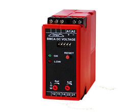 Rød batterivagt BMCA DC VOLTAGE med sort frontpanel, der viser LED-indikatorer, reset-knap og justeringsknapper.