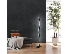 EGLO Lasana gulvlampe i sort med en drejet form, der lyser op med 4700 lm hvidt lys. Lampen står på et trægulv ved siden af en sofa og en stor grøn plante.