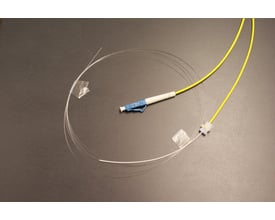En LC/UPC pigtail med simplex G657A fiber i gul LSZH-kappe, 1.7mm diameter og semi-tight buffer, arrangeret i en cirkel.