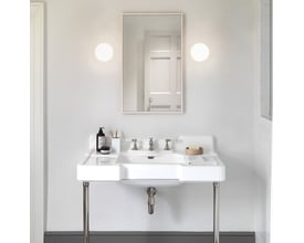 Et moderne badeværelsesinteriør med to Astro Zeppo væglamper flankerende et stort spejl over en hvid porcelænsvask.