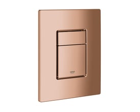 Nærbillede af Grohe Skate Cosmopolitan betjeningspladens blanke Warm Sunset overflade, med Grohe logo diskret placeret.