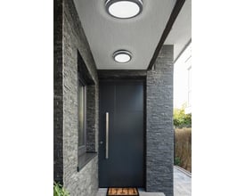 To Piave loftlamper med sensor fra TRIO Lighting monteret på en antracitsten beklædt facade ved en mørk hoveddør, ideel til udendørs belysning.