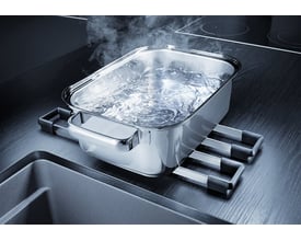 Blanco Etagon 500-U UXI køkkenvask i antracit komposit med en gryde med kogende vand placeret på et praktisk tilbehørsstativ over vasken.