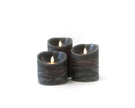 Tre LED bloklys i sortmeleret ægte stearin med bevægelige flammer står arrangeret på en ren hvid baggrund.