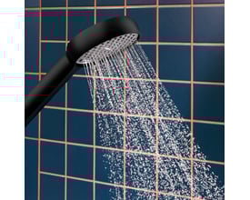 Hansgrohe Activera Select S bruserhoved i mat sort, der udsender en vandstråle mod mørkeblå, firkantede fliser.