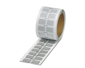 Rulle med Phoenix Contact EMLP (27x18)R SR skilte, viser 500 stk. sølvfarvede, ubeskrevne kunststofmærker på 27x18 mm.