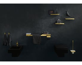 Hansgrohe AX universal krog i blank krom monteret ved siden af to sorte håndklæder på en mørk væg.