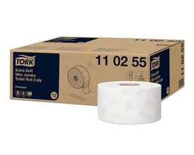 Tork Extra Soft Mini Jumbo toiletpapir i hvidt, trelags papir, vist som en rulle foran den brune produktkarton.