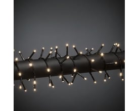 Nærbillede af Konstsmide lyskædens 400 varmhvide LED lys på en sort ledning, vist på en mørk baggrund.