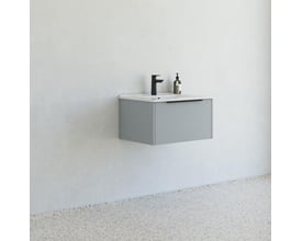 Dansani Mido møbelpakke i glat blå mat, vist monteret på en hvid væg med et terrazzo gulv og minimalistisk badeværelsesæstetik.