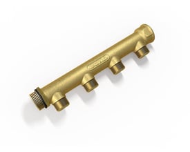 Nærbillede af Wavin fordelerrøret i messing, viser detaljer på de fire 1/2" afgange og 3/4" indgang.