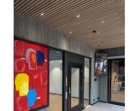 SLC Pixel X5 LED downlights monteret i et moderne loft med trælameller og betonvægge, som giver en stilfuld belysning.