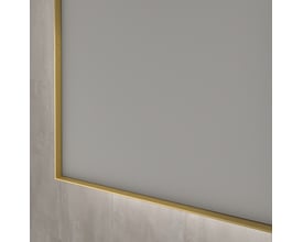 Sanibell INK SP32 spejl, 80x80cm, med en slank, børstet mat guld aluramme, der viser en detalje af kanten mod en grå væg.