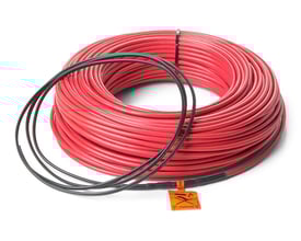 Nærbillede af det røde Heatcom 6 mm varmekabel rullet sammen, med sort tilslutningskabel og advarselsetiket synlig.