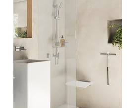 Smedbo living væghængt klapsæde i krom på et moderne badeværelse, vist udfoldet og klar til brug ved siden af en bruseniche.