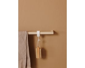 Metallbude Vana håndklædestang i beige, med et moderne firkantet design, hænger på en sandfarvet væg og har et håndklæde samt en børste hængende.