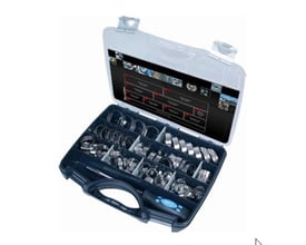 Tættere billede af syrefast spændebåndssortiment i åben sort kuffert, der viser et udvalg af spændebånd og en skruetrækker.